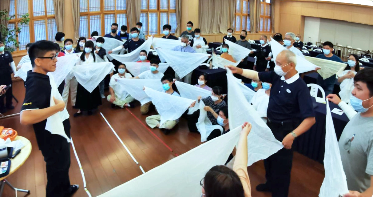 三角巾包紮主要用於包紮、懸吊受傷肢體、固定敷料、骨折固定等。授課講師正手把手地為學員示範步驟。
